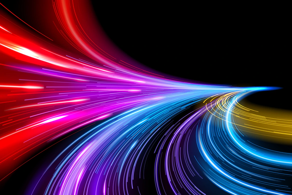 Red, pink, blue and gold light trails converging across a black background